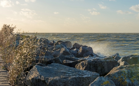 Storm over a lake along a dike at fallの写真素材