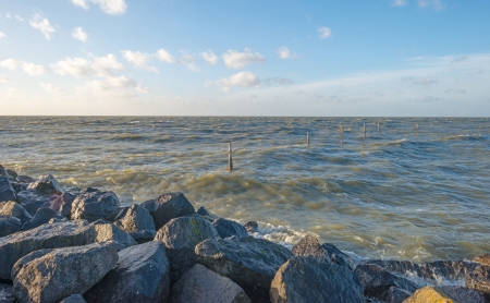 Storm over a lake along a dike at fallの写真素材