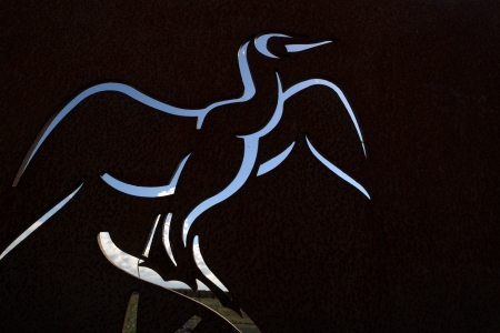 Bird etched in steel in a landscapeの写真素材