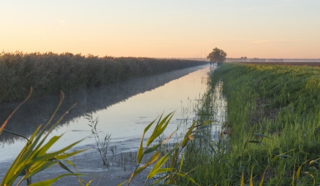 Canal through the countryside at dawn の写真素材