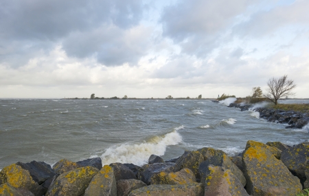 Storm over a lake along a dike at fall
