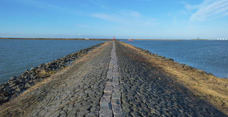 Boat sailing in a lake along a dike