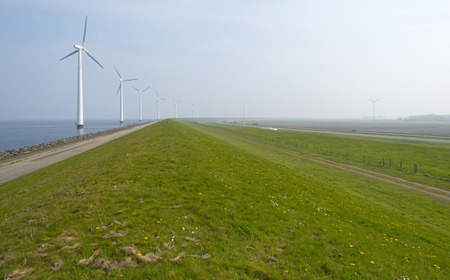 Wind turbines in a lake along a dike