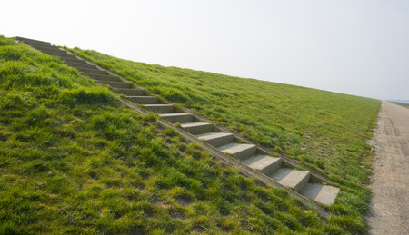 Stony stairs on a dike along a roadの写真素材