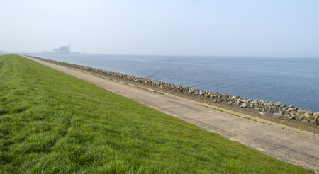 Road on a dike along a lake in spring