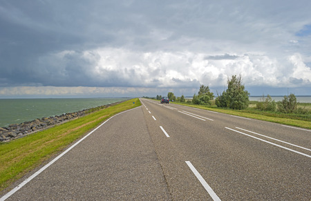 Road on a dike along a lakeの写真素材