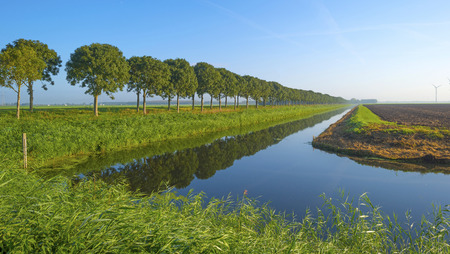 Canal through a rural landscape at sunriseの写真素材