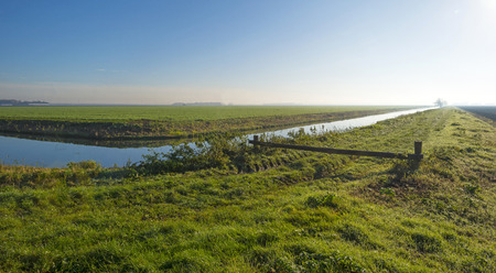 Canal in a rural landscape at sunrise in autumnの写真素材