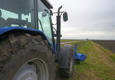 Tractor parked along a canal in winter
