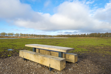 Bench in a muddy field in winterの写真素材