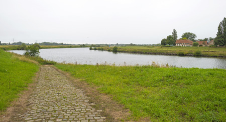The shore of a river through a hazy landscape in summer