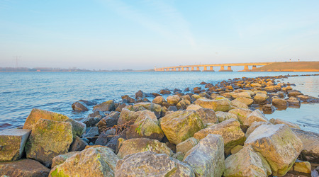 Dike along a lake in winter at dawn