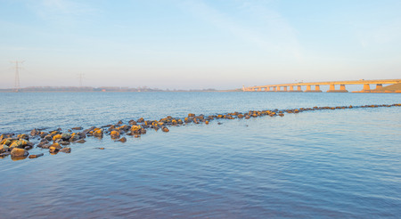 Bridge over a lake in winter at sunriseの写真素材