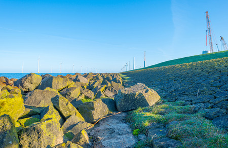 Wind turbines along a dike at sunrise