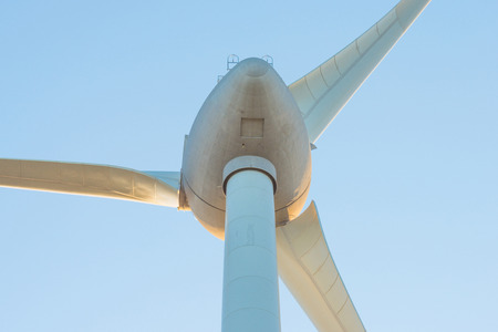 Wind turbine in a blue sky at sunrise