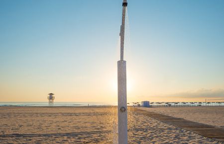 Shower on a beach at sunriseの写真素材