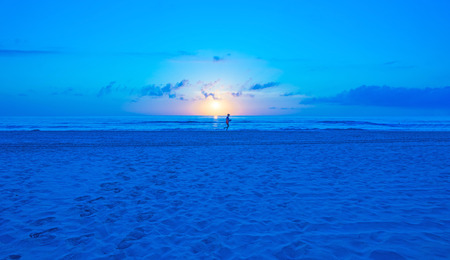 Sunrise over a beach in blueの写真素材