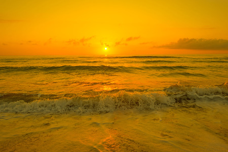 Sunrise in orange over a beach in summerの写真素材