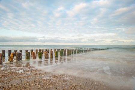 Sea along a sandy beach in the light of sunrise in summerの写真素材
