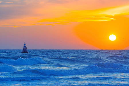 Sea along a sandy beach in the light of sunset in summerの写真素材