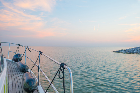 Boat sailing on a lake at sunset in summerの写真素材