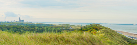 Skyline of a city behind sand dunes in sunlight in summerの写真素材