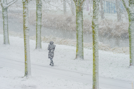 Woman walking in the snow in winterの写真素材