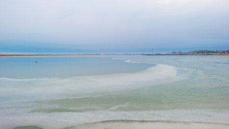 Edge of a frozen lake along a dike in winterの写真素材
