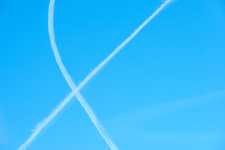 Contrails in a blue sky in sunlight in winter