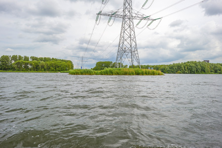 Powerline over the shore of a lake in springの写真素材