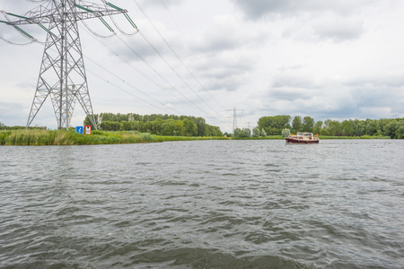 Powerline over the shore of a lake in springの写真素材