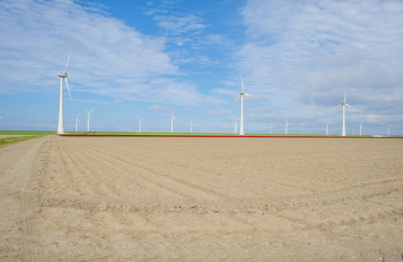 Furrows in a plowed field below a blue sky in sunlight in spring