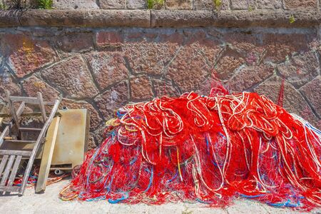 Panorama of the colorful town of Bosa along a river and hills in sunlight in springの写真素材