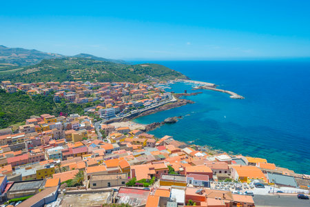 View of the town of Castelsardo on a hill and along the sea in sunlight in springのeditorial素材