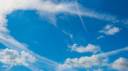 Panorama of white clouds in a blue cloudy sunlit bright sky with contrails in summer, Almere, Flevoland, The Netherlands, July 15, 2020の写真素材