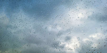 Raindrops on a window pane in a cloudy, stormy and rainy autumn, Almere, Flevolandの写真素材