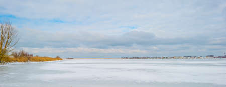 Snowy edge of a white frozen lake in wetland in winter, Almere, Flevoland, The Netherlands, February...