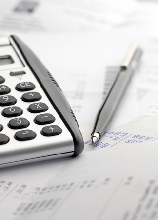 A calculator, pen, and financial statementの写真素材