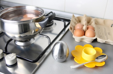 composition of eggs, stew pan, egg shape timer, eggcup end eggcartoon in the kitchen