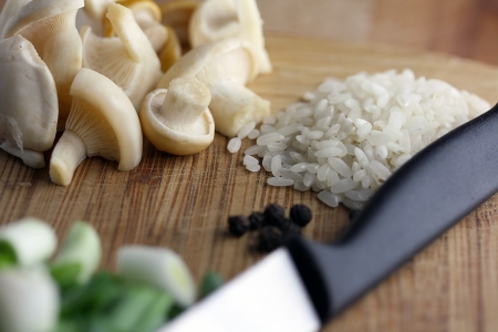 sliced mushrooms, sliced onion, rice and knife on cutting board の写真素材