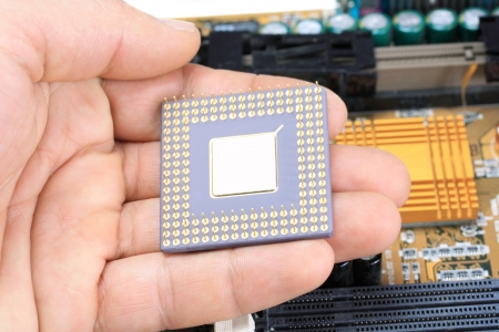 PC processr in human hand in front of Mother Boardの写真素材