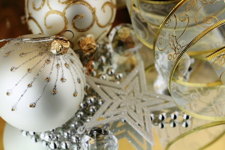 Two Christmas baubles, cristal sphere, star and ribbon on golden backgroud with reflectionsの写真素材