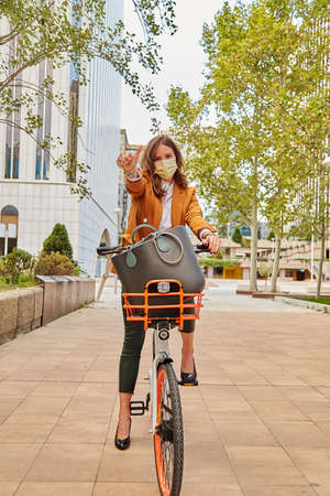 Caucasian woman using a rental bike - Woman wearing a face maskの写真素材