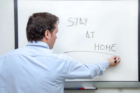 Adult man in blue shirt writing on whiteboard Stay at homeの写真素材