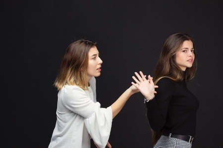Portrait of two happy women friends with loving gestures laughing on a black background - Concept of friendshipの写真素材