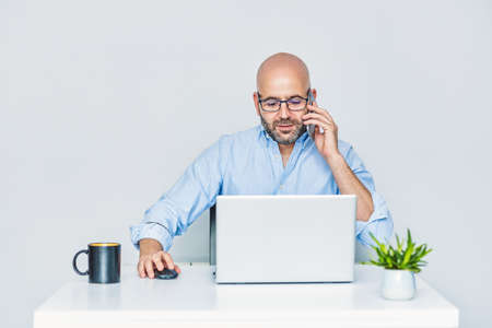 A self-employed entrepreneur working from home with a laptop. Adult bald manの写真素材