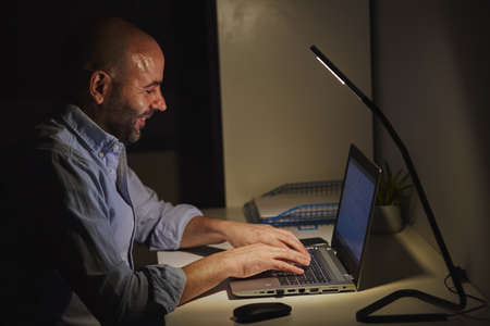A self-employed entrepreneur working from home with a laptop. Adult bald manの写真素材