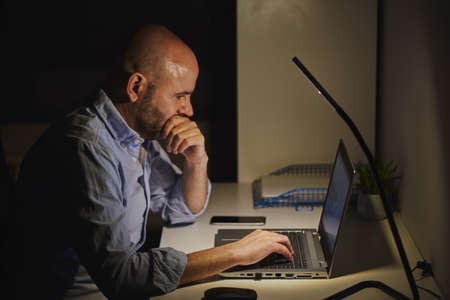 A self-employed entrepreneur working from home with a laptop. Adult bald manの写真素材
