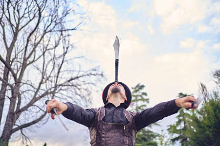 Man juggling knives in park