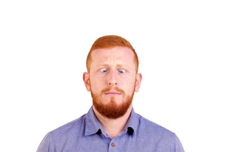 Red-haired man with funny comical beard crosses his eyes, grimaces, isolated on white background. High quality photoの写真素材